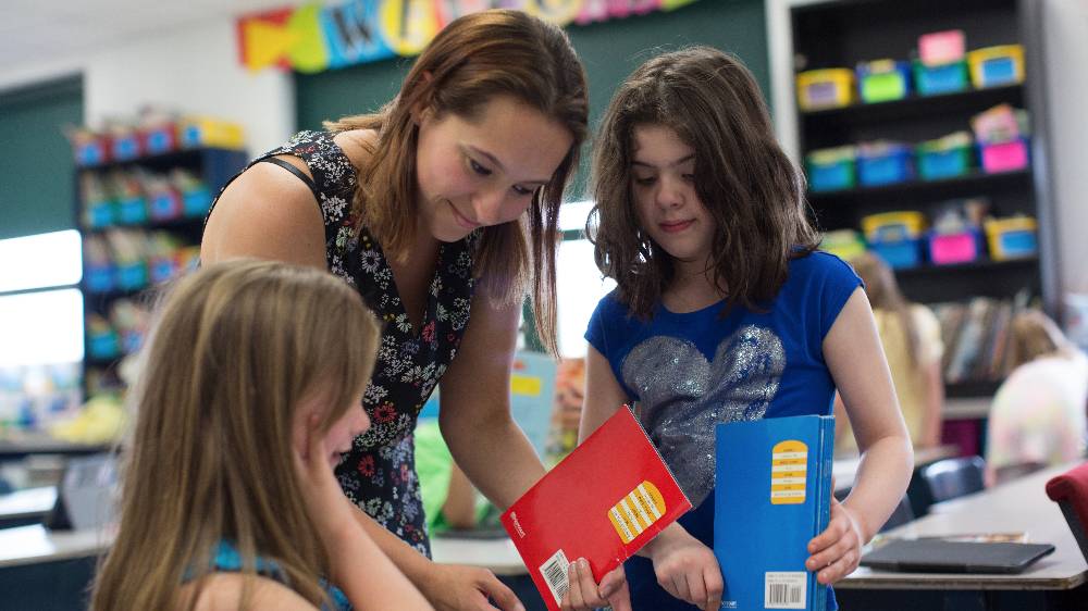 A student helps a child in the learning and language center.